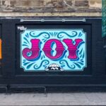 Joy graffiti on a wall that is representing Londons creative culture