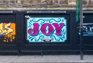 Joy graffiti on a wall that is representing Londons creative culture