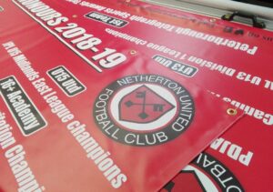 multiple pvc banners displaying a football club event