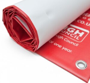a rolled up printed banner showing stainless steel eyelets representing its heavy duty nature