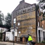 a hand painted sign on a wall in london